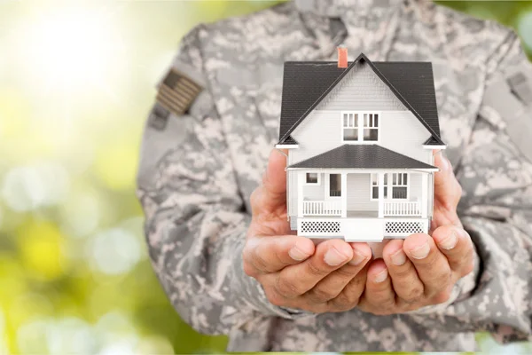 Real Estate Image, Military person holding small home